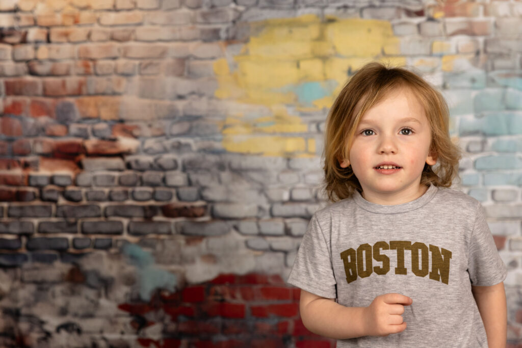 Young boy in front of a wall