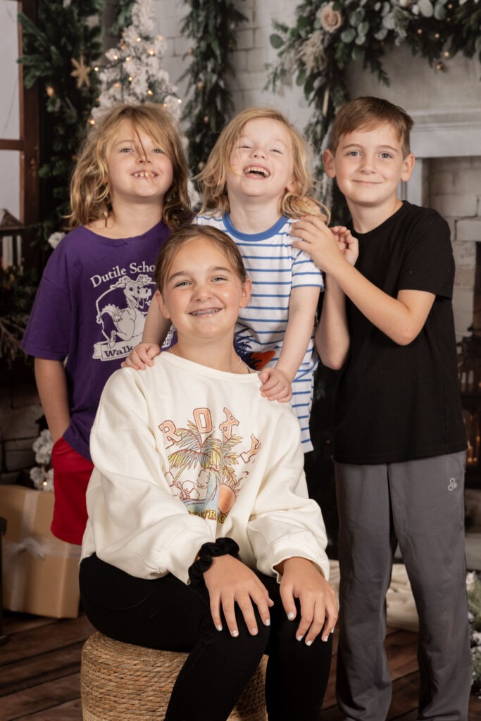 Group of four childhood friends smiling at eachother