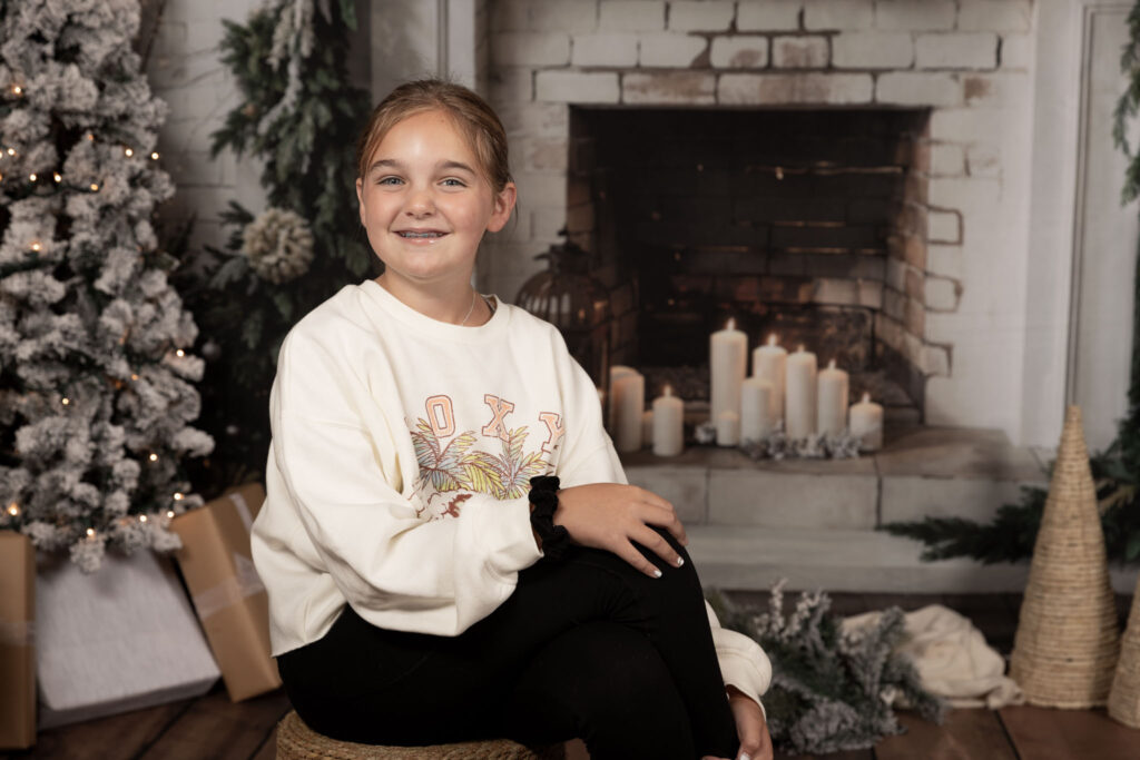 Young girl sitting and smiling at the camera.