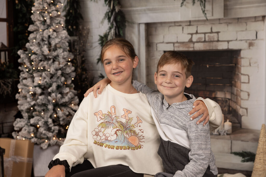 Two siblings sitting next to each other.