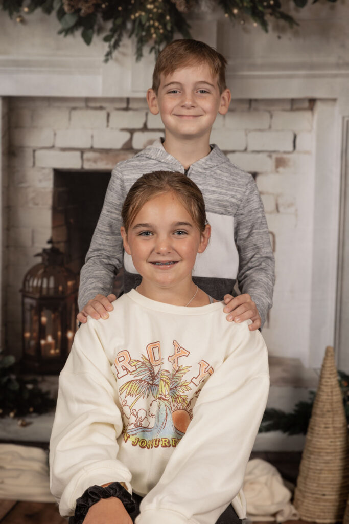 Two siblings smiling at the camera.