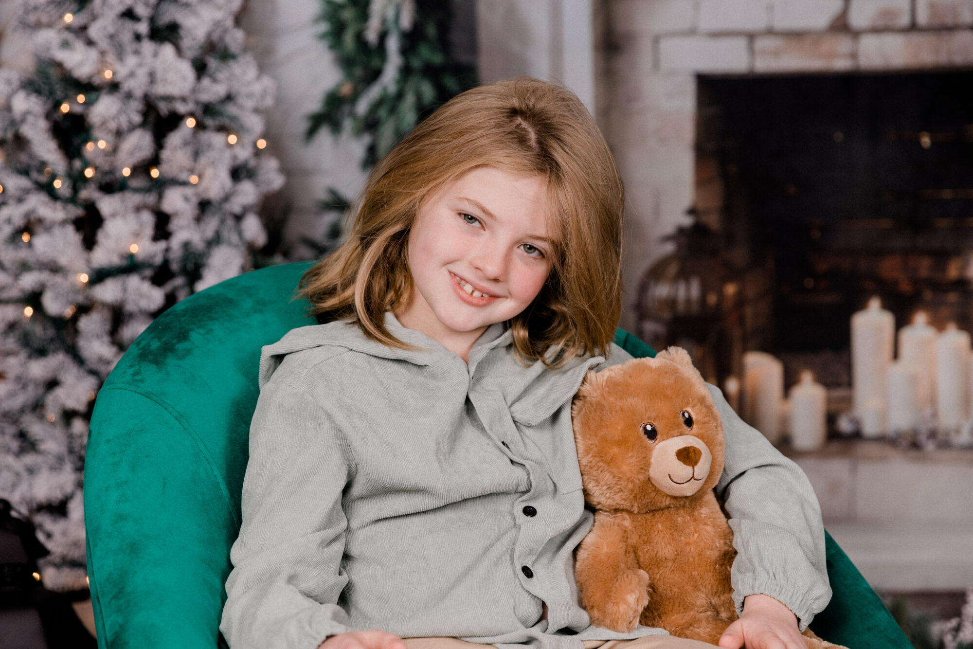 A child sitting in a green chair smiling.