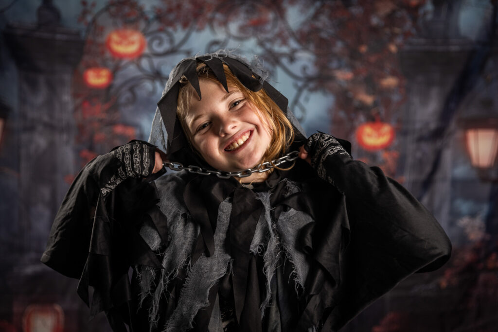 A young boy smiles in a halloween costume.