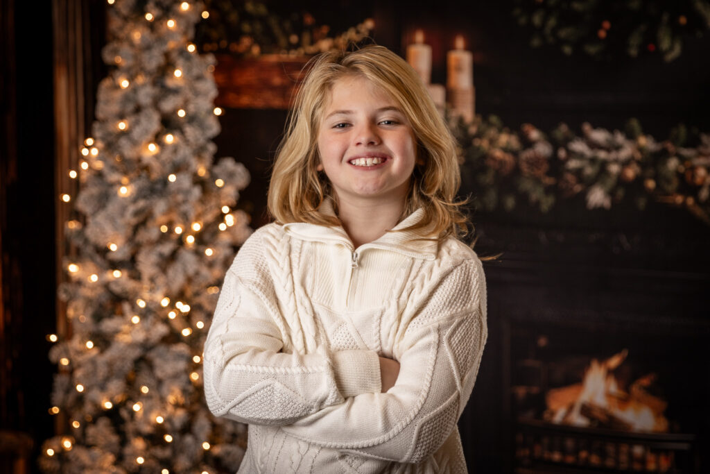 Woodlawn Studios Holiday Portraits Billerica MA 2025 teen boy smiling in front of a tree.